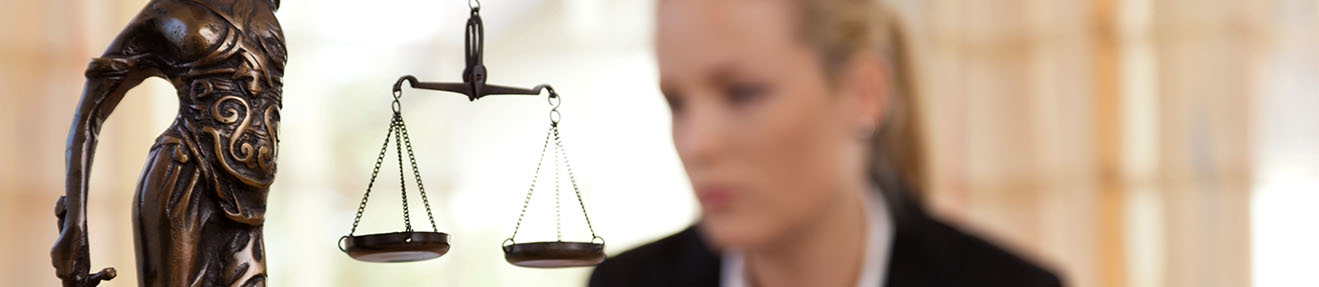 A woman works behind a statue of Lady Justice.